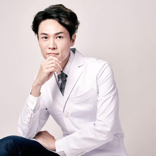 身穿白大褂、手托下巴的顏百駿醫師。