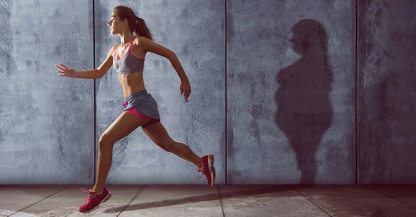女人奔跑，牆上映出更大身影的影子。輕鬆減脂。
