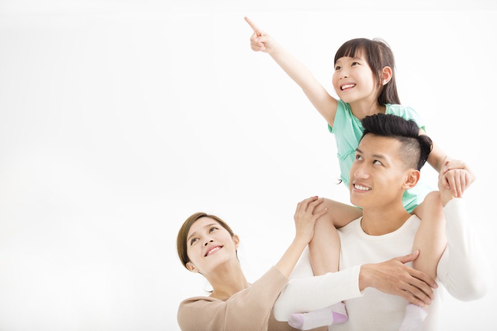 幸福的家庭:爸爸把女兒扛在肩上,媽媽在一旁看著。
