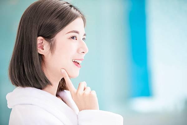 幸福的女人摸著下巴,展現健康的肌膚。非常適合春季護膚流程。