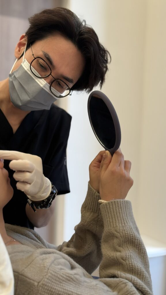 醫生正在為顧客進行醫美諮詢,顧客拿著鏡子查看。4D 童妍針